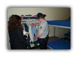 A drill sergeant shows Stephanie how to hang clothes TYAC style